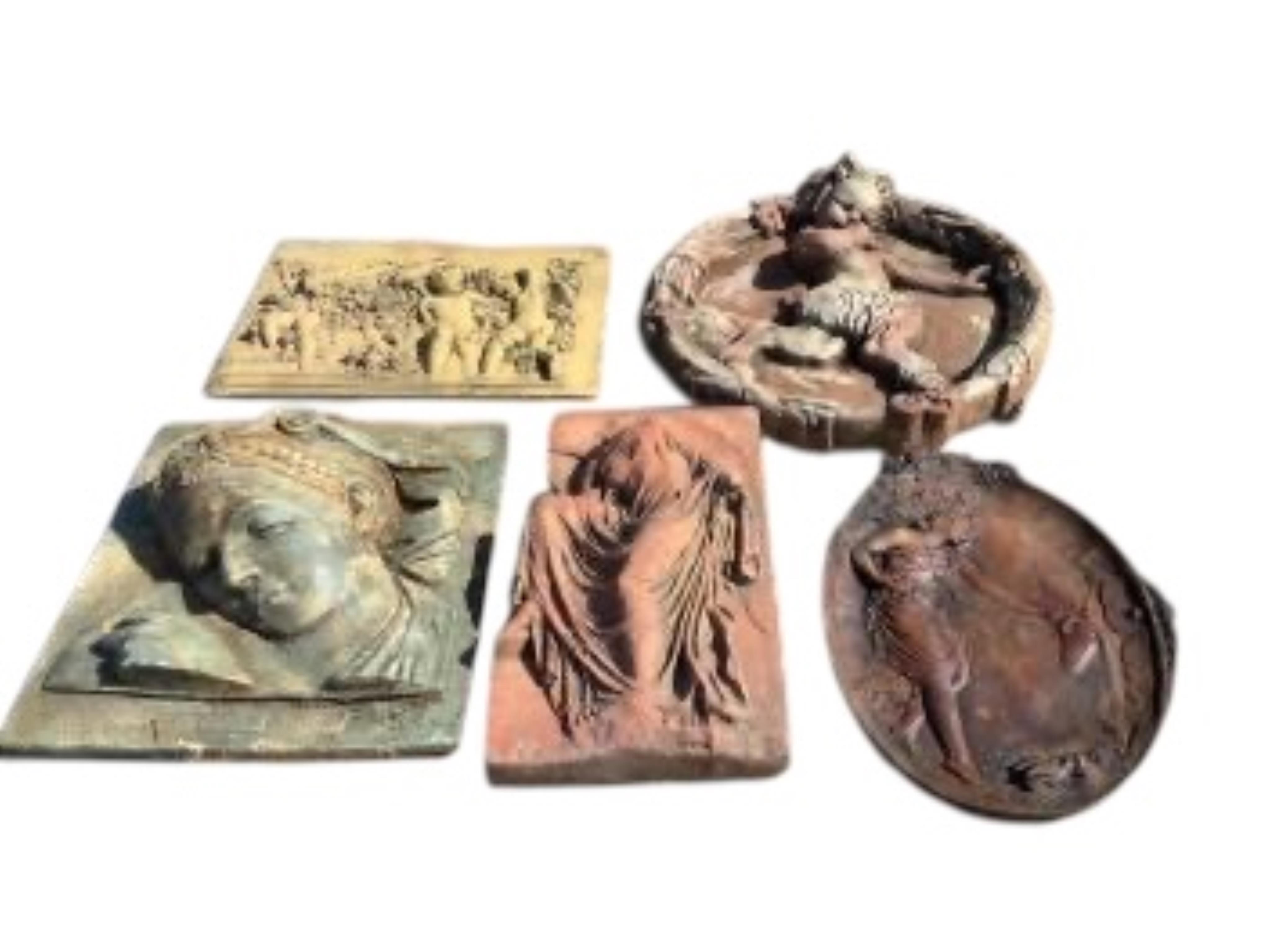 Five cast stone and terracotta garden wall plaques, largest diameter 41cm